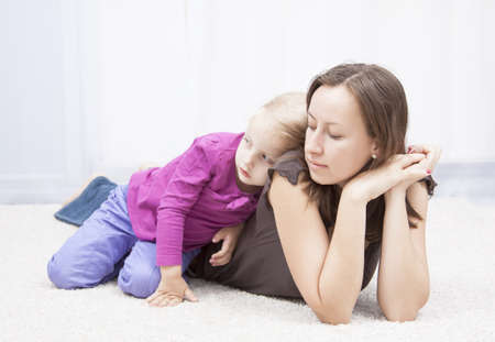 mother with her dpughter laying on the floorの写真素材