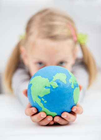 little girl holding the earth globeの写真素材