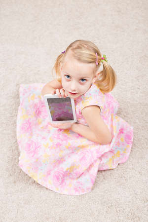 blonde little girl with her tableteの写真素材