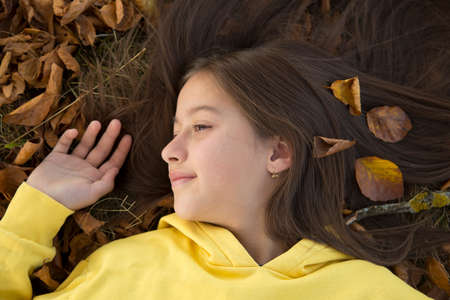 smile girl in autumn colored leafの写真素材