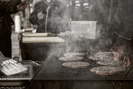 Cooking burgers on the street in the evening.の写真素材