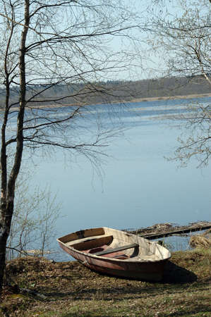 Rowboat stranded ashore at a lake in Russiaの写真素材