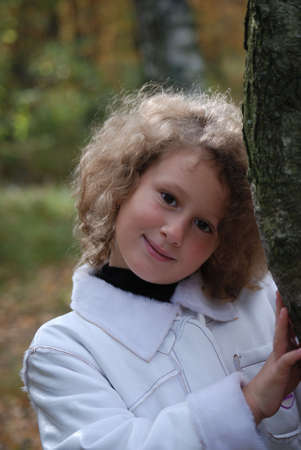 Little girl in a park next to a birchの写真素材