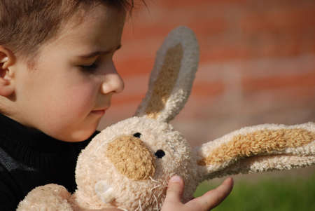 Little boy with a toy hare in handsの写真素材