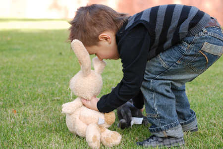 Little boy with a toy hare in handsの写真素材