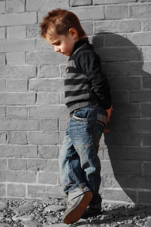 little boy on a background a brick wallの写真素材