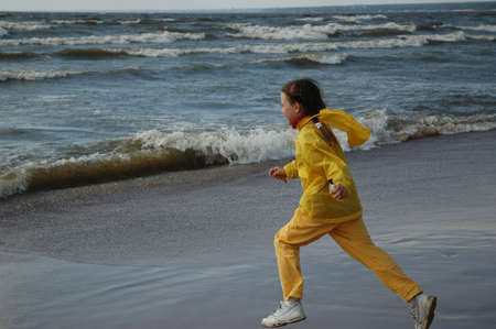 girl in yellow clothes, playing ashore seaの写真素材
