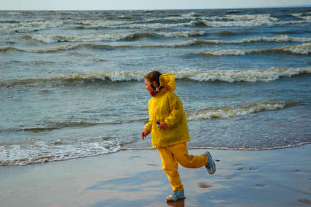 girl in yellow clothes, playing ashore seaの写真素材
