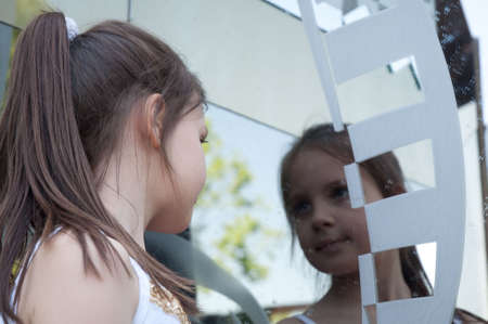 portrait of little girl next to a mirrorの写真素材