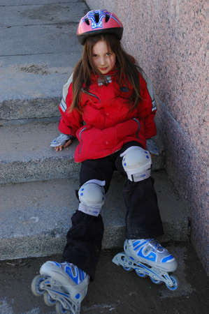 Young girl rollerblading, in a protective clothing