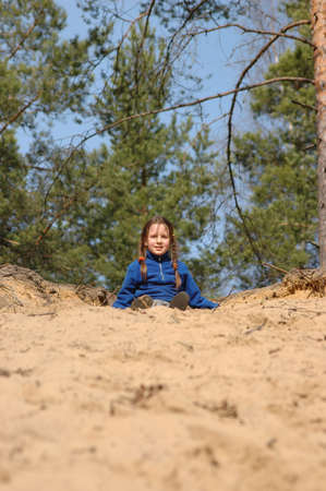 girl, jumping from a sandy slopeの写真素材