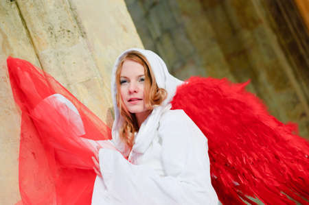 Beautiful young angel with red wingsの写真素材