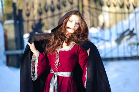 The girl in a medieval dress and a black raincoatの写真素材