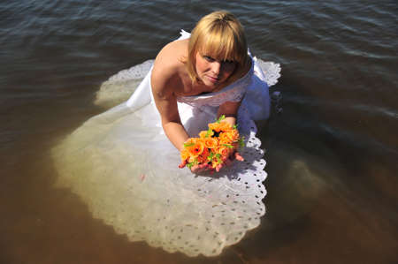 portrait of bride dressed in wedding gown in waterの写真素材