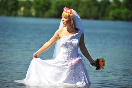 portrait of bride dressed in wedding gown in waterの写真素材
