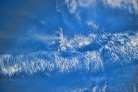 Dark and bright blue sky with white cloudsの写真素材