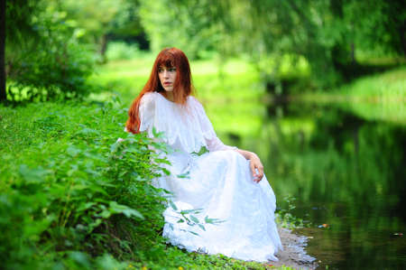 The girl in a white dress in park at the riverの写真素材