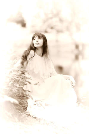 The girl in a white dress in park at the riverの写真素材