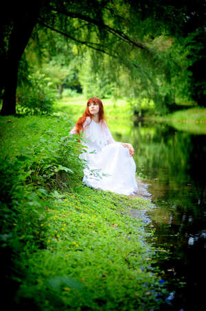 The girl in a white dress in park at the riverの写真素材