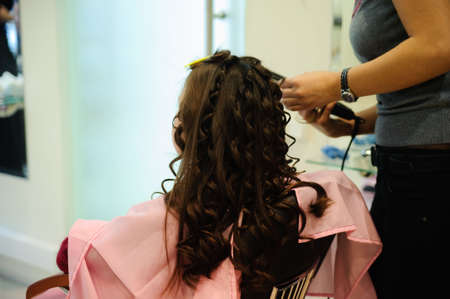 The little girl doing a hairdress in a hairdressing salonの写真素材