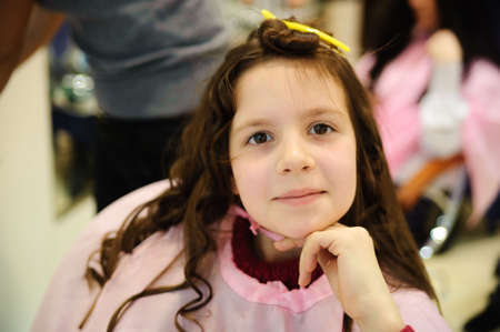The little girl doing a hairdress in a hairdressing salonの写真素材