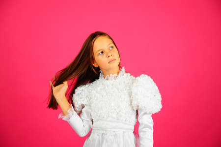 The little girl in a white dress on a pink backgroundの写真素材