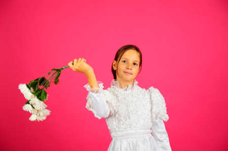 The little girl in a white dress on a pink backgroundの写真素材