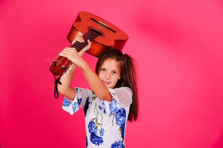 The little girl raising a guitarの写真素材