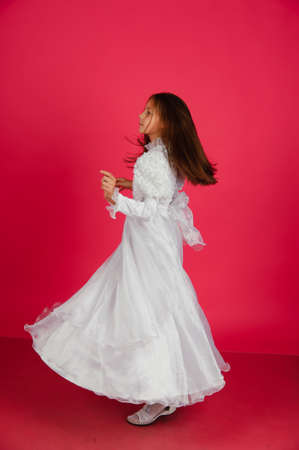 The little girl turned in a white dressの写真素材