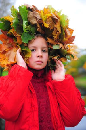 The little girl with a wreath from autumn leaves on a headの写真素材