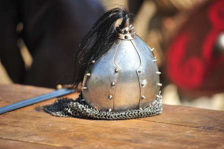 Helmet and sword of Vikings lying on a wooden bench