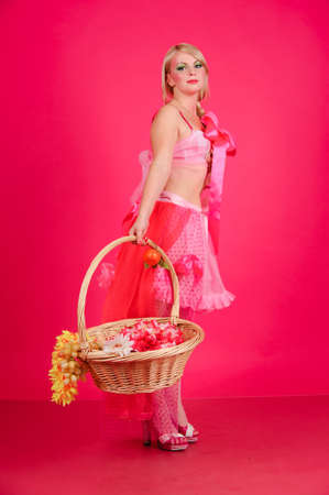 A blonde with a basket of fruitの写真素材