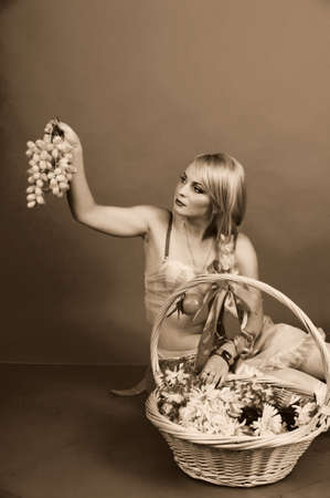 A blonde with a basket of fruitの写真素材