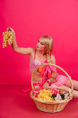 A blonde with a basket of fruitの写真素材