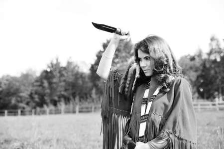 girl dressed as an Indian with a knife in his handの写真素材