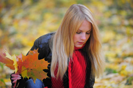 girl with autumn maple leaves in the hands の写真素材