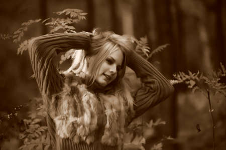 a beautiful young blonde in the background of autumnの写真素材