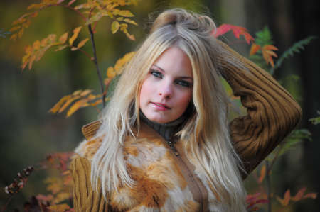 Close-up portrait of young woman with yellow leavesの写真素材