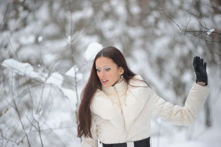 Young woman in coat outside in snowの写真素材