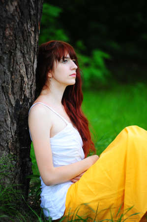 Beautiful young redhead girl thinkingの写真素材