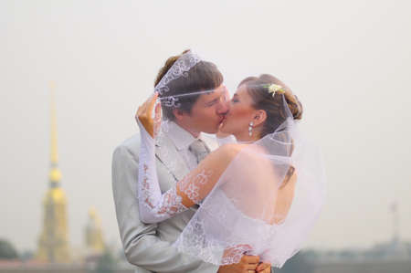 A couple about to kiss under a veil outdoorsの写真素材