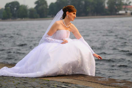 Closeup portrait of bride dressed in wedding about waterの写真素材