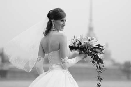 happy bride with a bouquet of white lilies