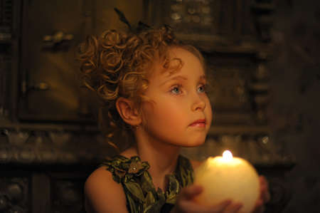 Young beautiful, girl portrait by glow of candlelightの写真素材