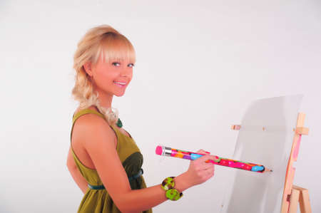 Beauty teenager girl painting on blank white canvasの写真素材