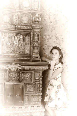 girl with retro hairdo about antique stoveの写真素材