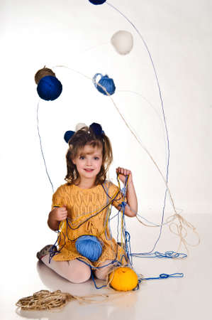 little girls play with balls of woolの写真素材