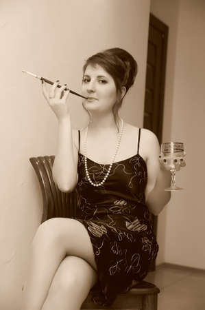 a woman with a cigarette holder and a glass