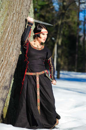 Portrait of the girl with a knife in a medieval dress の写真素材