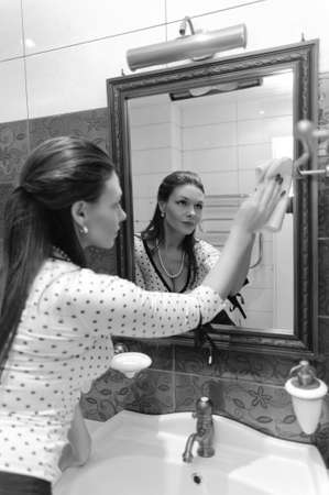 woman wash the mirror and looking into itの写真素材
